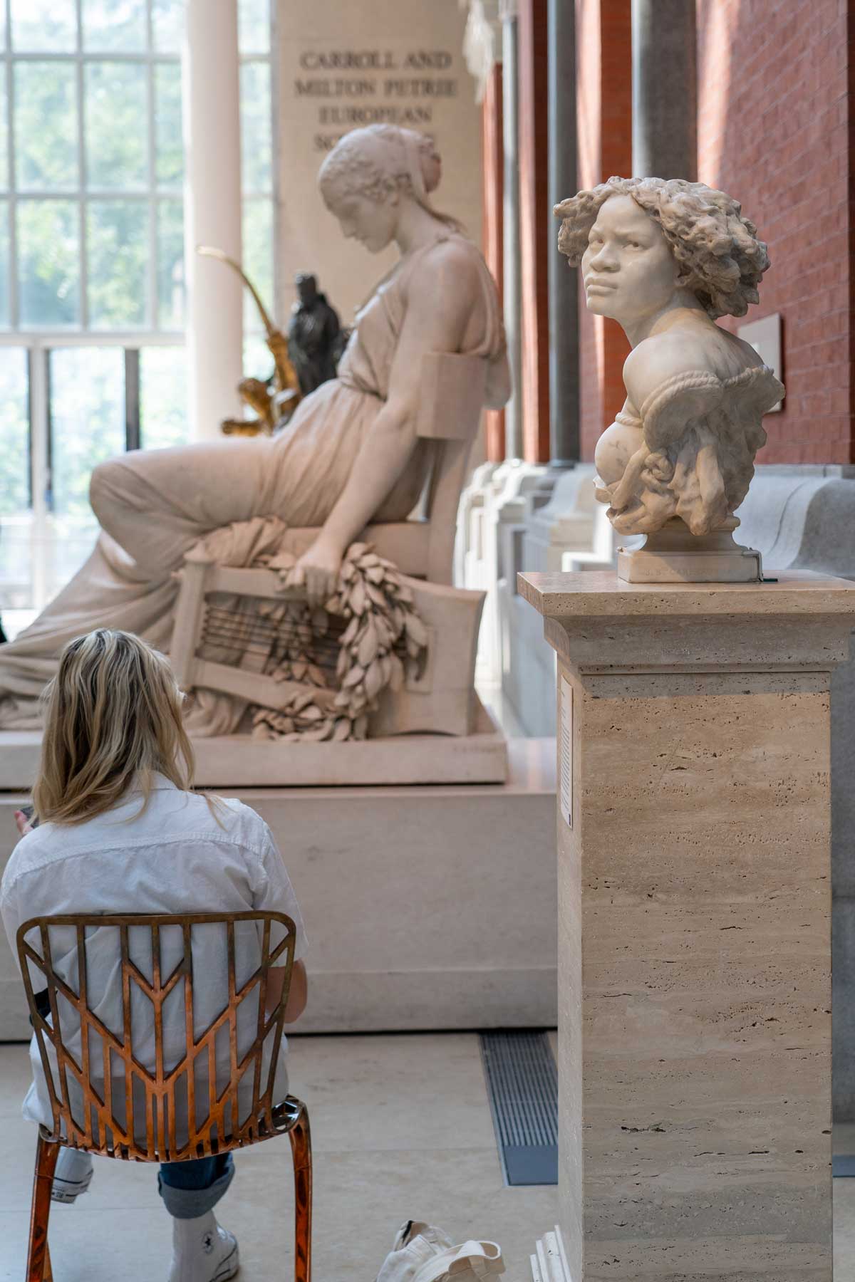 Woman sitting among statues